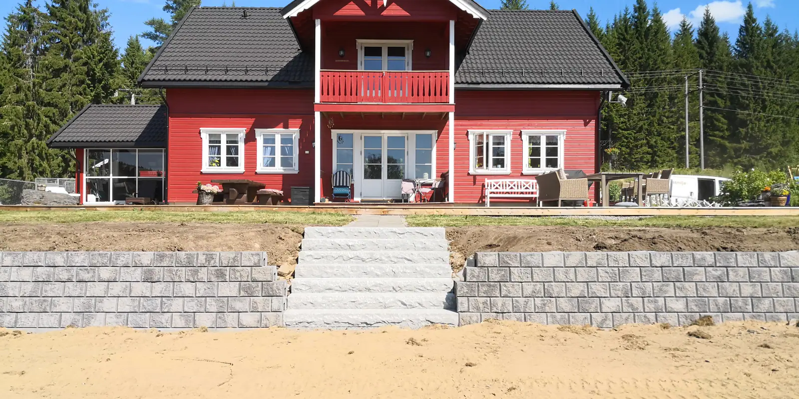 Støttemur og granittrapp foran hus